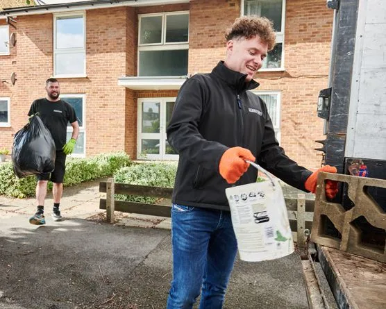 Two men removing scrap metal and rubbish