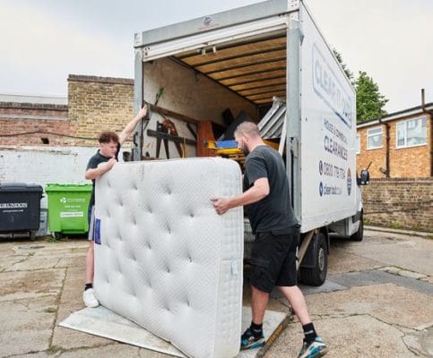 a mattress being loaded into a van as part of a house clearance in Epsom