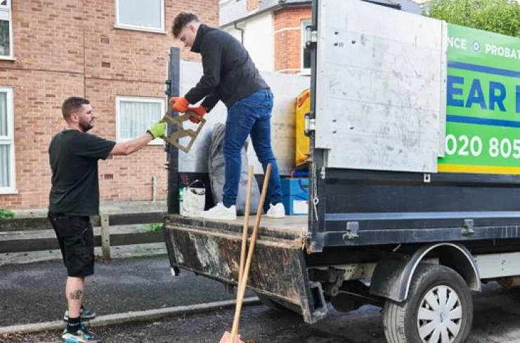 Two men loading a van as part of a garden clearance